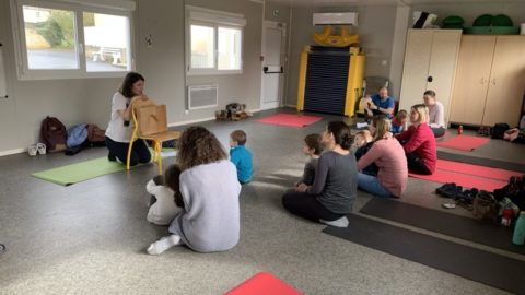 parents et enfants participant à un atelier de yoga avec un animatrice
