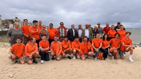 groupe des sauveteurs nageurs et des élus posant devant la plage de Grandcamp Maisy