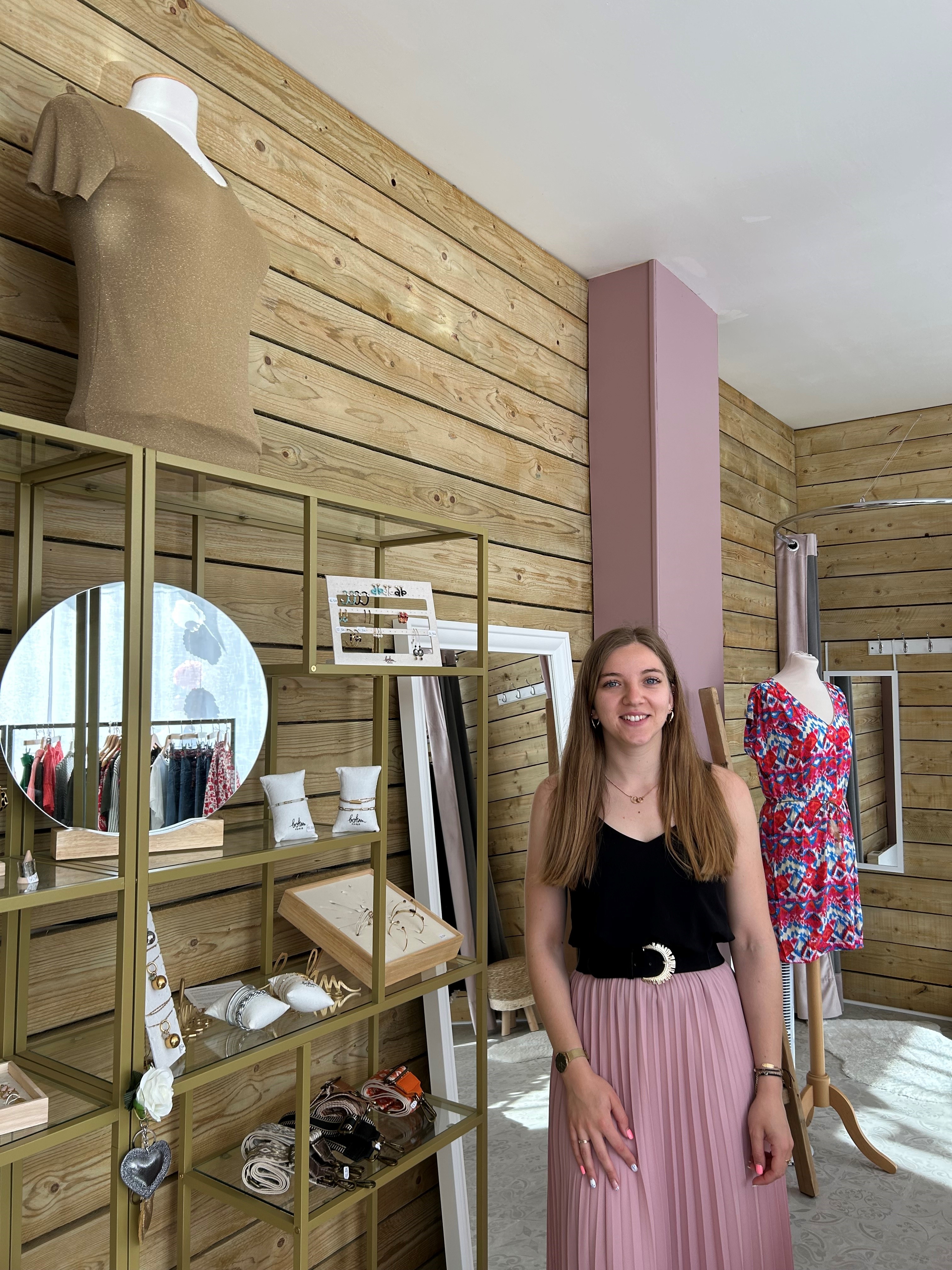 Alizée, la gérante, posant dans sa boutique devant des bijoux